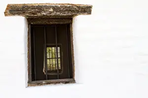 Aligned Prints: A rustic window with a view of a garden through a room in an historic early California building