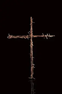 Suffering Prints: Rusty barbwire cross isolated on black background. Religious war