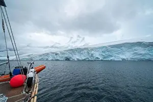 sailing boat in Antarctica, yacht navigation through icebergs and sea ice