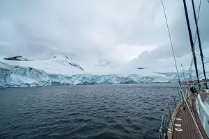 sailing boat in Antarctica, yacht navigation through icebergs and sea ice