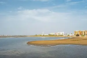 sand beach at Isla Cristina at the Costa de la Luz in Andalusia with view to town and lighthouse