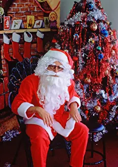Imitation Prints: Santa Claus (Father Christmas) sitting in store setting by Christmas tree