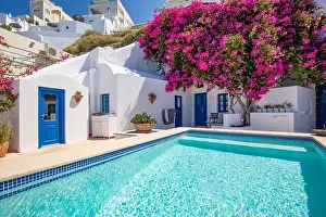 Santorini, Greece landscape, pool caldera view with flowers blue doors. Romantic couple destination with sunny sky, wonderful summer hotel resort