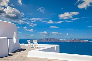 Santorini island caldera view with chairs and white architecture, romantic mood, couple travel vacation landscape destination scenic. Tourism view