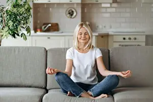 Dreaming Prints: Satisfied attractive middle aged female sits on sofa at home and chilling
