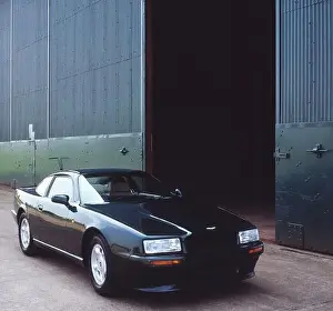 Mode Of Transport Prints: Scanned image of a Classic Aston Martin black car parked outside an aircraft hangar in Bedford