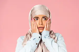 Shocked Prints: scared muslim girl in hijab, isolated on pink