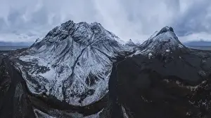 Scenic aerial view of river estuary located in valley near snowy mountain range on cold winter day in southeast Iceland