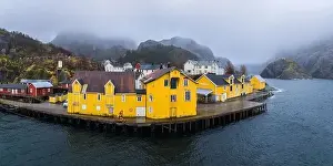 Flakstadoya Prints: Scenic drone view of small settlement with typical colorful residential houses at seaside surrounded by huge rocky