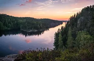 Scenic forest landscape with beautiful sunset and sunlight at summer evening in Finland