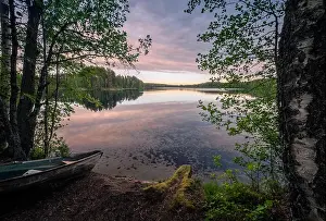 Scenic landscape with idyllic lake view and boat at summer evening in Finland