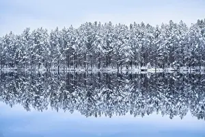 Scenic landscape with lake reflection and snow at winter evening