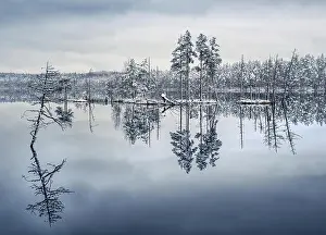 Scenic landscape with lake reflection and snow at winter evening