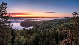 Scenic landscape with lake, sunrise and fog at tranquil misty morning in Aulanko, nature reserve, Finland