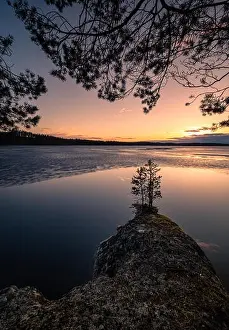 Scenic landscape with melting lake and sunset at beautiful spring evening in Finland