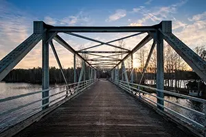 Sun Beams Prints: Scenic landscape with old metal bridge and road at autumn evening in Finland