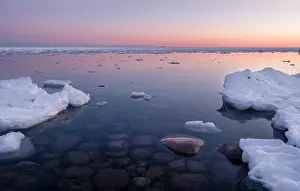 Scenic seascape with sunset and nice stones under the water at winter time