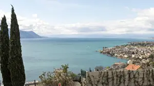 Peaceful Scene Prints: A scenic view of Lake Geneva, with mountains in the background and a charming town nestled along the shoreline