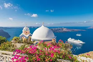 Scenic view of traditional cycladic houses with flowers in foreground, Oia village, Santorini, Greece. Summer travel landscape, sea view. Amazing
