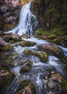 Scenic waterfall landscape with green moos stones and flowing river at beautiful summer day in Gollinger, Austria