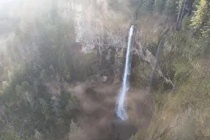 A scenic waterfall plunges over 500 feet from a cliff into the Columbia River Gorge, Oregon. Forests and rivers predominate in this PNW region