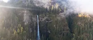 A scenic waterfall plunges over 500 feet from a cliff into the Columbia River Gorge, Oregon. Forests and rivers predominate in this PNW region
