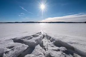 Scenic winter landscape with bright sunlight and sun at winter day in lake Finland