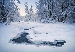 Scenic winter landscape with flowing river and morning light in Finland