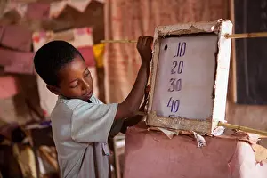 Teacher Prints: A school boy uses a teacher learning material during a maths class in a classroom in Finote Selam