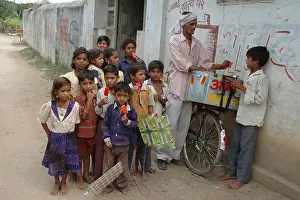 Licking Prints: School going children eating red color ice cream in Village Manghawa District Narsinghpur Madhya Pradesh India - ANA