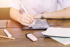 School student using touchscreen tablet computer device to learning and writing homework, modern technology for education