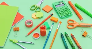 Pens Prints: School supplies background. Stationery on green color