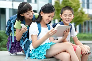 12 13 Years Prints: Schoolchildren playing digital tablet together