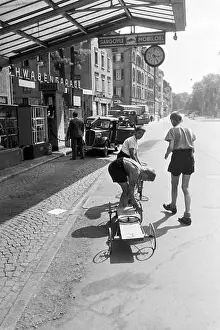 Strasse Prints: Schuljungen ölen die Räder ihres selbstgebauten Holzwagens an einer Tankstelle