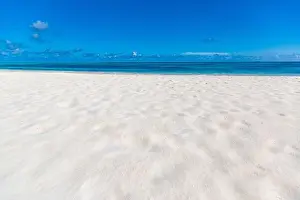 Sea sand sky concept. Closeup of sand on beach and blue summer sky, calmness and inspiration nature concept