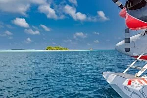 Images Dated 3rd May 2018: Seaplane at tropical beach resort. Maldives air travel and tourism blue sea with tropical island