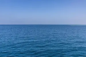 Seascape with sea horizon and almost clear deep blue sky background