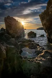 Sky Clouds Prints: A seascape at sunset with sun rays and sky reflection on a rock pool