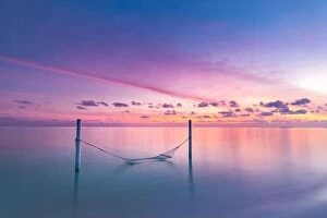 Images Dated 16th December 2018: Seascape view of sunset over Maldives lagoon with empty hammock hanged over water