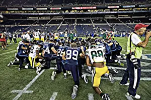 Turf Prints: Seattle Seahawks and the Green Bay Packers praying after an NFL football game