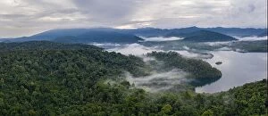 Aerial Landscape Collection: Seen from above, early morning mist drifts over tropical islands in Raja Ampat, Indonesia