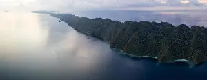 Seen from above, remote islands are surrounded by coral reefs in Raja Ampat, Indonesia. This region is known as the heart of the Coral Triangle