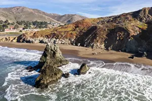 Seen from an aerial perspective, the cold waters of the Pacific Ocean wash against the rocky Northern California coastline in Marin