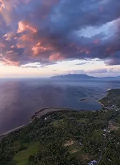 Seen from an aerial view, the tropical island of Flores is illuminated at sunset