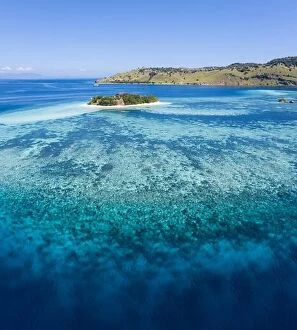 Images Dated 8th May 2019: Seen from a bird's eye view, an idyllic tropical island is surrounded by a healthy coral reef in