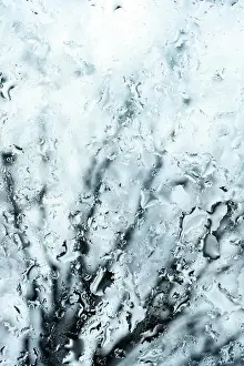 (selective focus) Close-up view of some drops of water on a glass during a rainy day