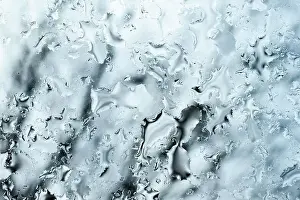 (selective focus) Close-up view of some drops of water on a glass during a rainy day