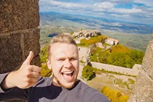 Selfie photo traveler man smiling Castello di lombardia in Enna Sicily, Italy