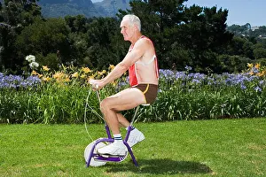 Senior Adult Prints: Senior adult man riding exercise bike