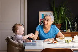 Ethnicities Prints: Senior asian woman feeding toddler grandaughter at table at home
